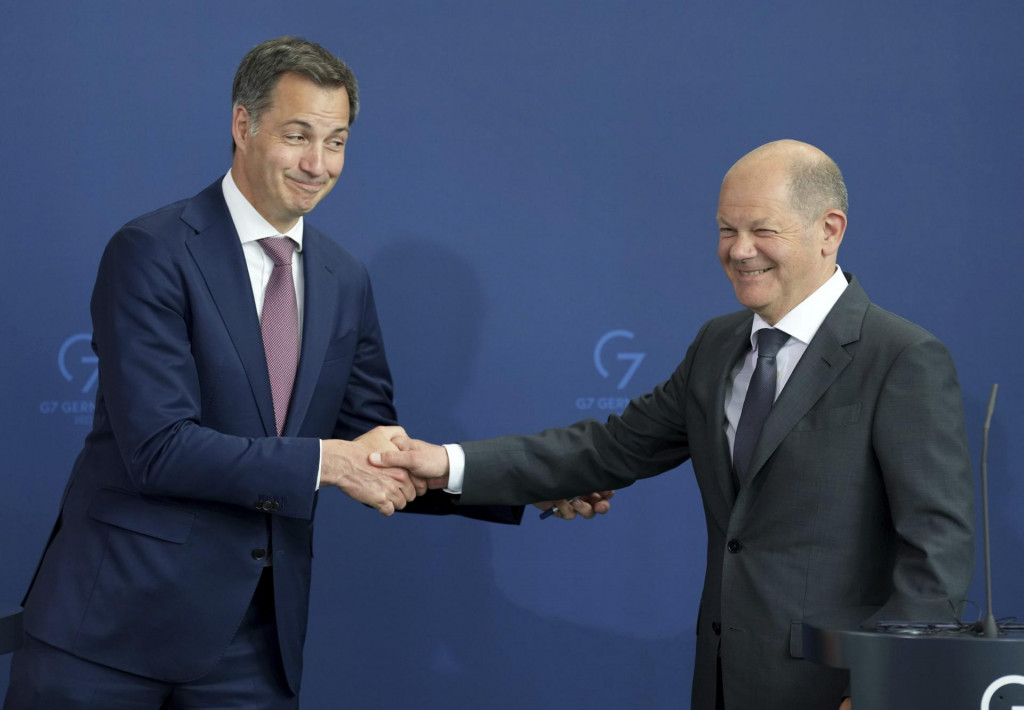 Na snímke zľava belgický premiér Alexander De Croo a nemecký kancelár Olaf Scholz si podávajú ruky počas spoločnej tlačovej konferencie pri ich stretnutí v Berlíne. FOTO TASR/AP

