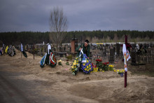 Volodymyr Bondar plače pri hrobe syna Oleksandra po pohrebe na cintoríne v Buči. FOTO: TASR/AP

