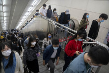 Ľudia s ochrannými rúškami kráčajú na stanici metra v čínskom Pekingu. FOTO: TASR/AP