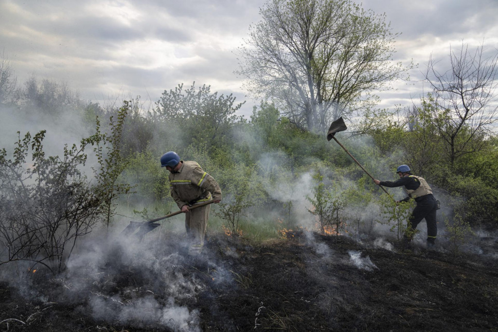 Hasiči hasia lesný požiar po ostreľovaní mesta Mykolajivka v Doneckej oblasti na východe Ukrajiny. FOTO: TASR/AP
