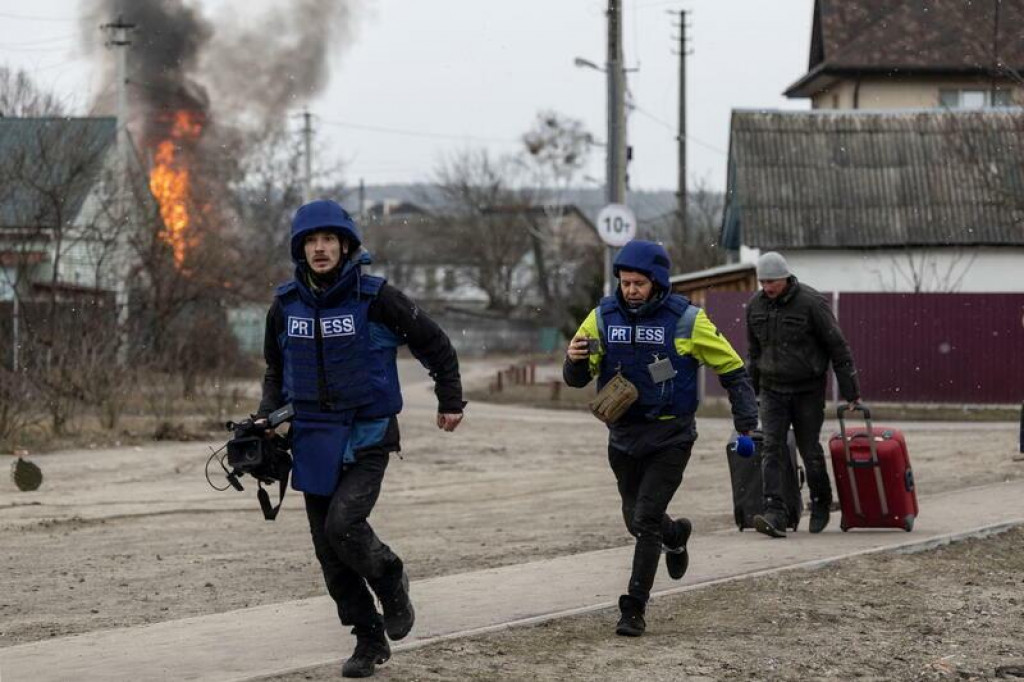 Novinári na Ukrajine, ktorí sa bežia ukryť pred ostreľovaním v Irpine. FOTO: REUTERS/Carlos Barria