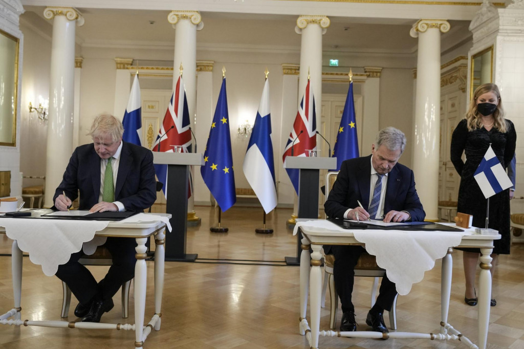 Britský premiér Boris Johnson a fínsky prezident Sauli Niinistö podpisujú dohodu o bezpečnostných zárukách počas stretnutia v Helsinkách. FOTO: TASR/AP

