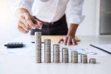 Business accountant or banker, businessman calculate and analysis with stock financial indices and putting growth stacking coin and financial costs wisely and carefully, investment and saving concept. FOTO: Shutterstock