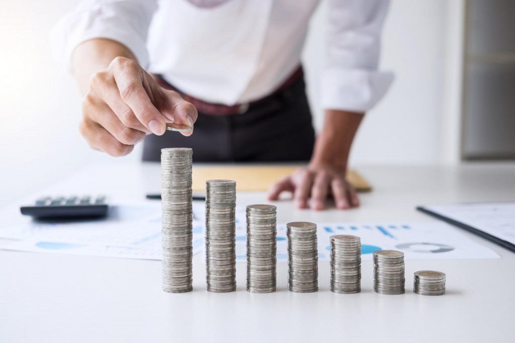 Business accountant or banker, businessman calculate and analysis with stock financial indices and putting growth stacking coin and financial costs wisely and carefully, investment and saving concept. FOTO: Shutterstock