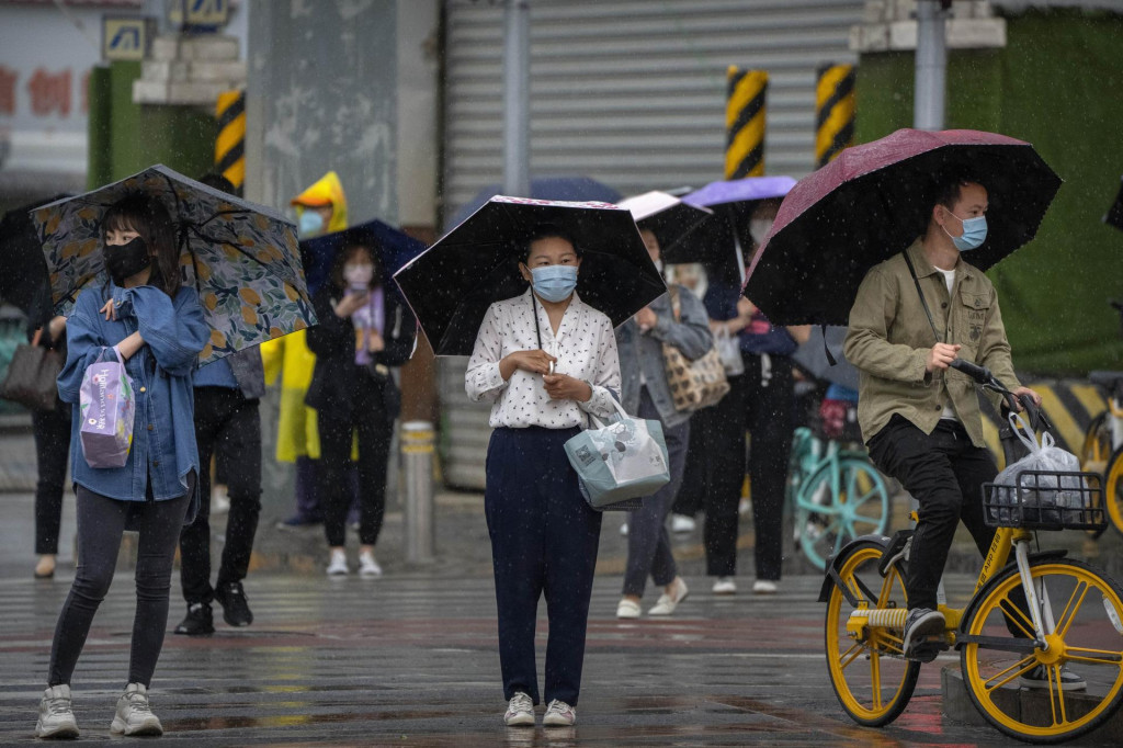 &lt;p&gt;Ľudia s ochrannými rúškami čakajú na križovatke v daždivom ráne v čínskom Pekingu, ilustračný obrázok.&lt;/p&gt;