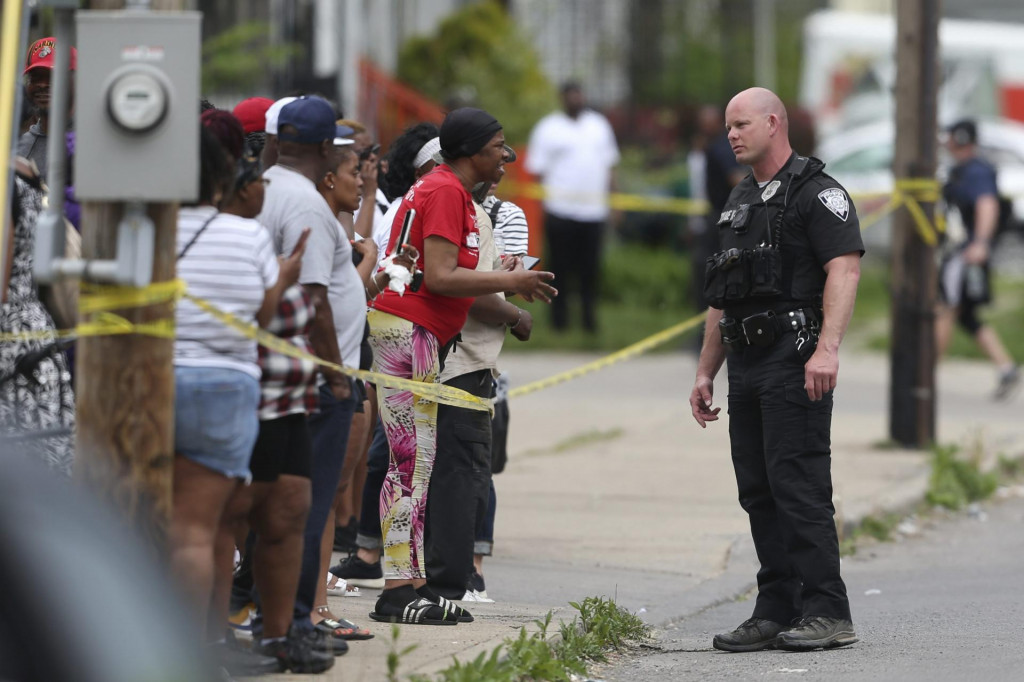 Policjat sa rozpráva s ľudmi po streľbe, ku ktorej došlo v predajni potravín a na priľahlom parkovisku v americkom meste Buffalo v štáte New York v sobotu 14. mája 2022. FOTO: TASR/AP