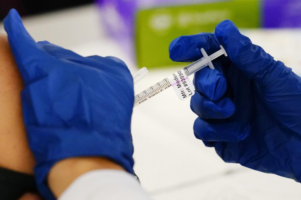 Zdravotník podáva vakcínu proti ochoreniu COVID-19 od spoločnosti Moderna v očkovacom centre v americkom meste Norristown. FOTO: TASR/AP

