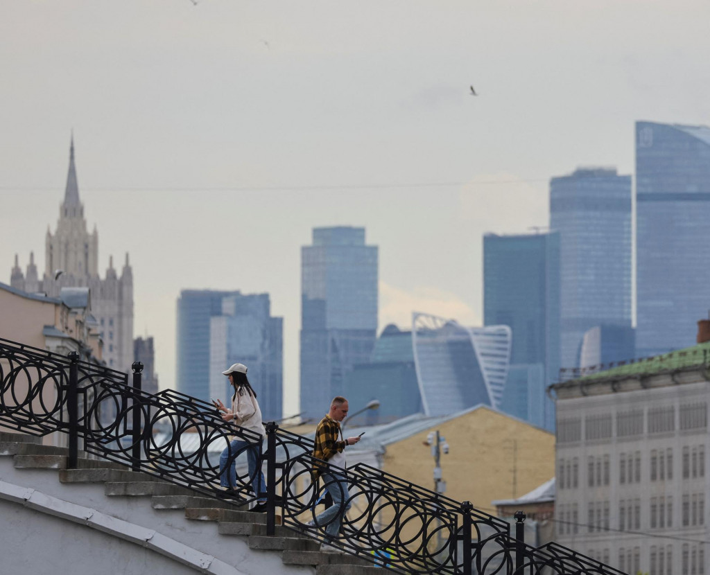Ľudia kráčajúci po moste v Moskve. FOTO: REUTERS