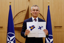 &lt;p&gt;Šéf NATO Jens Stoltenberg drží v rukách vlajky Švédska a Fínska. FOTO: Reuters&lt;/p&gt;