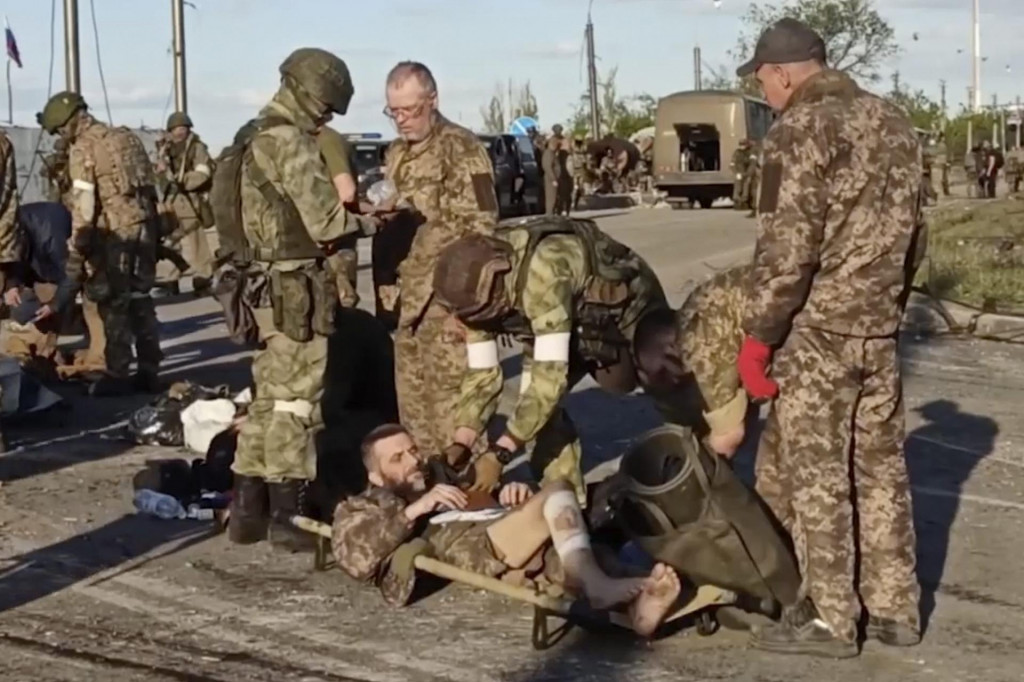 Na videosnímke ruskí vojaci prehľadávajú ukrajinských vojakov počas ich evakuácie z obliehanej oceliarne Azovstaľ v ukrajinskom Mariupole. FOTO:TASR/AP
