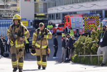 Na snímke hasiči odchádzajú z uzavretej arény Ice Hall pred štartom zápasu A-skupiny medzi Nemeckom a Dánskom v Helsinkách. FOTO: TASR/AP
