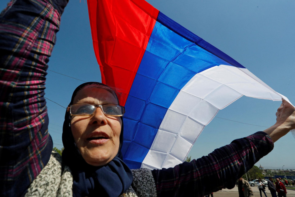 Žena drží ruskú vlajku. FOTO: REUTERS/Alexander Ermochenko