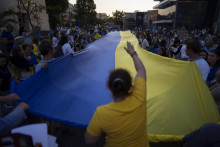 &lt;p&gt;Obrovská ukrajinská zástava počas protestu v Tel Avive. FOTO: TASR/AP&lt;/p&gt;