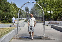 Muž v Bratislave prechádza cez vodný rozprašovač v Parku Andreja Hlinku počas horúceho letného dňa. FOTO: TASR/Pavol Zachar