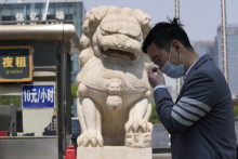 &lt;p&gt;Muž s ochranným rúškom kráča okolo sochy čínskeho hliadkujúceho leva v Pekingu. FOTO: TASR/AP&lt;br /&gt;
&lt;br /&gt;
 &lt;/p&gt;
