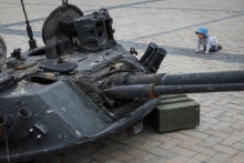 &lt;p&gt;Dieťa sleduje zničený ruský tank. FOTO: REUTERS&lt;/p&gt;