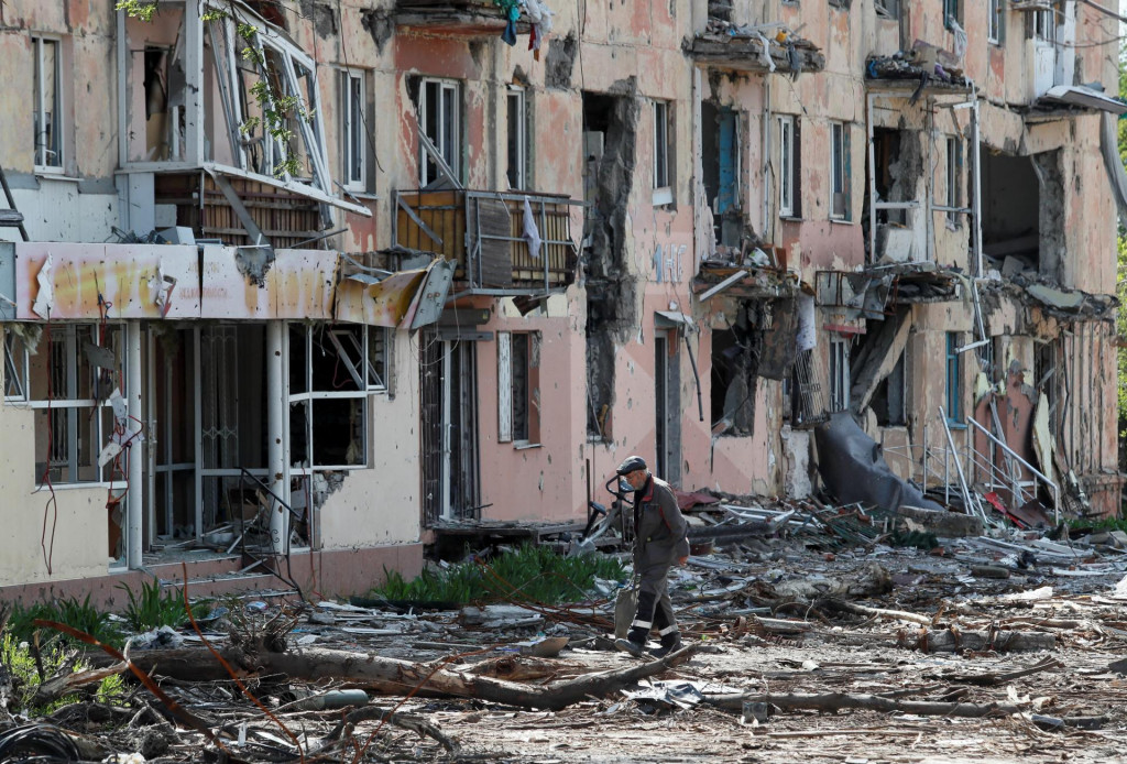 Obyvateľ sídliska v Mariupole kráča blízko zničenej obytnej štvrte. FOTO: REUTERS