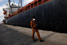 Bezpečnostný personál kráča pred nákladnou loďou s humanitárnou pomocou z Indie uprostred hospodárskej krízy v prístave v Kolombe na Srí Lanke. FOTO: Reuters/Adnan Abidi