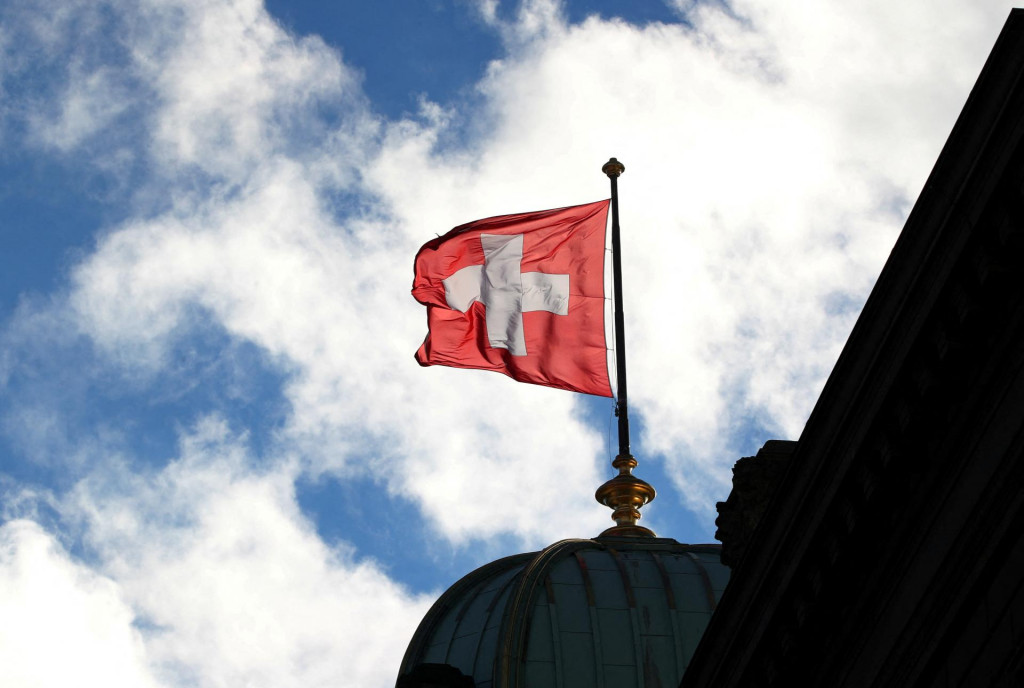 Na federálnom paláci v Berne vo Švajčiarsku je vyobrazená švajčiarska vlajka. FOTO: Reuters