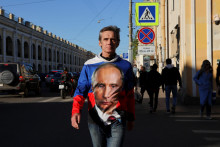 Muž v Petrohrade má oblečené tričko s podobizňou Vladimira Putina. Snímka: Reuters