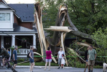 &lt;p&gt;Obyvatelia Ottawy sledujú strom zničený počas búrky v Ottawe v sobotu 21. mája 2022. FOTO: TASR/AP&lt;/p&gt;