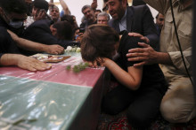 Ilustračná snímka z Teheránu: Syn zavraždeného plukovníka iránskych revolučných gárd Sajjáda Chodája plače na jeho truhlou. FOTO: TASR/AP