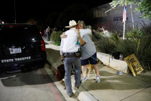 Žena objíma texaského rangera pred občianskym centrom Ssgt Willie de Leon Civic Center, kam previezli študentov zo základnej školy Robb po streľbe, v Uvalde v Texase. FOTO: REUTERS