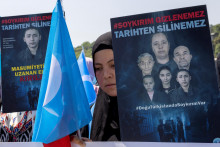 Ujgurjka drží vlajku Východného Turkestanu a transparent s nápisom: ”Genocída je neskrývateľná, nemožno ju vymazať z histórie” počas protestu proti Číne neďaleko čínskeho konzulátu v Istanbule v Turecku, 26. mája 2022. FOTO: REUTERS/Umit Bektas