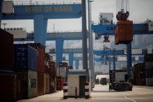 &lt;p&gt;Vodič sa pozerá, ako sa na jeho nákladné auto nakladá kontajner z nákladnej lode, ktorá kotví v prístave Haifa v Izraeli. FOTO: Reuters &lt;/p&gt;