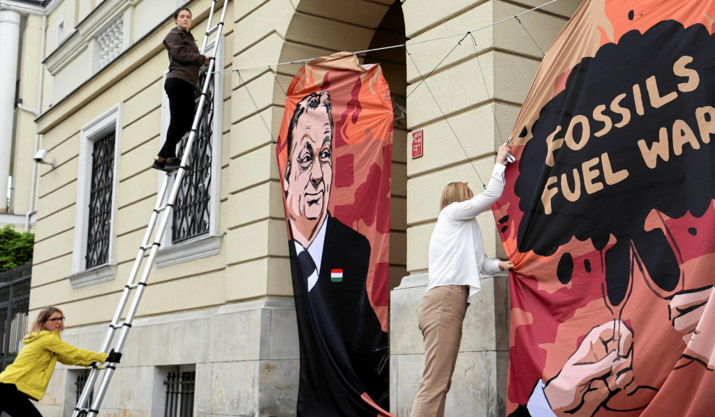 Aktivisti Greenpeace vyvesili pred maďarským veľvyslanectvom vo Varšave transparent zobrazujúci maďarského premiéra Viktora Orbána počas protestu proti maďarským dodávkam fosílnych palív z Ruska. FOTO: Reuters