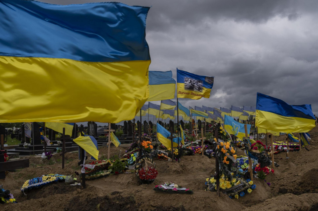 Na snímke ukrajinské vlajky vejú nad hrobmi padlých vojakov na cintoríne v Charkove 22. mája 2022. FOTO: TASR/AP