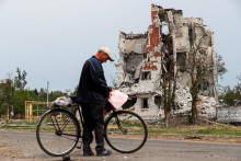 &lt;p&gt;Muž drží bicykel, keď stojí neďaleko budovy zničenej počas ukrajinsko-ruského konfliktu v meste Rubižne v Luhanskej oblasti. FOTO: Reuters &lt;/p&gt;