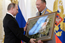 Generálplukovník Alexander Dvornikov odovzdáva prezidentovi Putinovi snímku z vojenského ťaženia na Blízkom východe. FOTO: TASR/AP