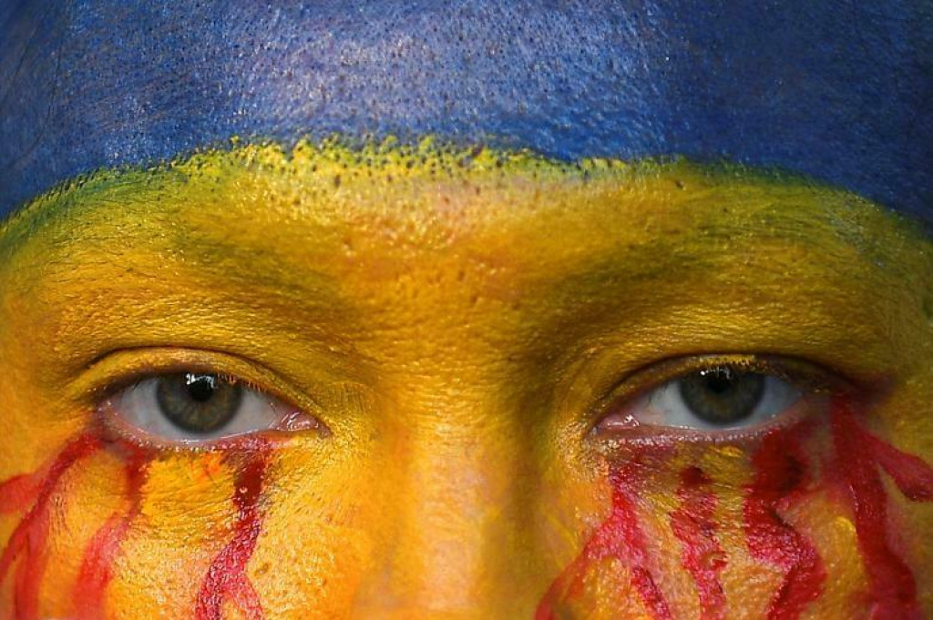 Tvár protestujúceho pomaľovaná v ukrajinských farbách. FOTO: REUTERS