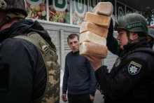 Policajti rozvážajú bochníky chleba pre obyvateľov, ktorí sa zdržiavajú vo východnom ukrajinskom meste Lyman, ktoré bolo silne ostreľované. FOTO: Profimedia