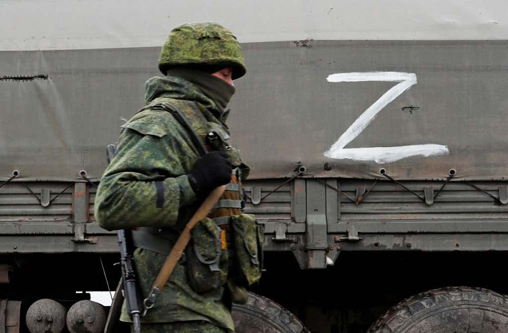 Vojak proruských milícií kráčajúci popri tanku. FOTO: REUTERS