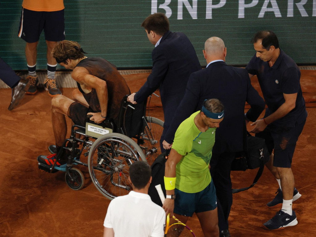 Nemecký tenista Alexander Zverev opúšťa kurt na vozíku po tom, čo si poranil členok v semifinále Roland Garros v Paríži proti Rafaelovi Nadalovi. FOTO: REUTERS