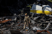 Ukrajinský vojak kráča popri zničenom stroji Antonov An-225 Mriya, najväčšom lietadle na svete, na letisku v meste Hostomel. FOTO: Reuters