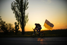 Cyklista jazdí s ukrajinskou vlajkou po ceste medzi mestami Odesa a Mykolajiv. FOTO: TASR/AP


