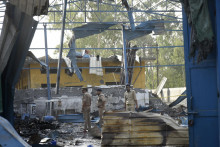 Policajti skúmajú miesto požiaru v indickom meste Hapur, kde zahynulo najmenej desať robotníkov. FOTO: TASR/AP