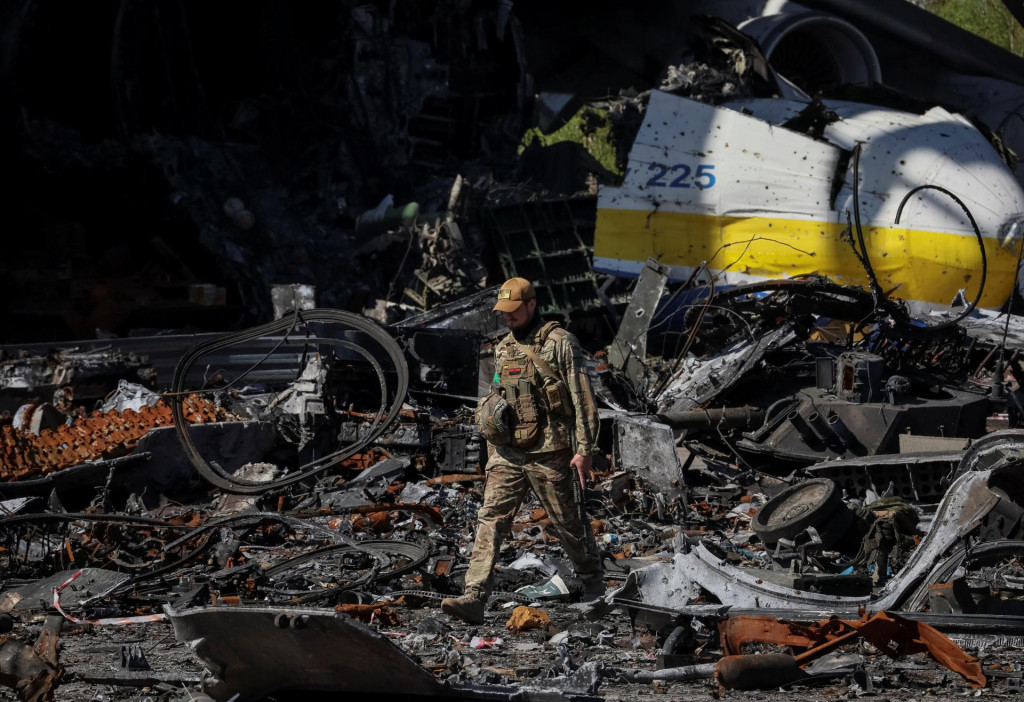 Ukrajinský vojak kráča popri zničenom stroji Antonov An-225 Mriya, najväčšom lietadle na svete, na letisku v meste Hostomel. FOTO: Reuters