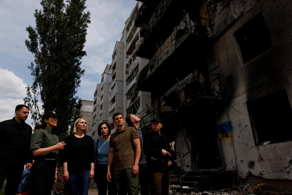 Veľvyslankyňa USA na Ukrajine Bridget Brinková a ukrajinská generálna prokurátorka Iryna Venediktová stoja pri poškodených budovách počas návštevy Borodianky. FOTO: Reuters