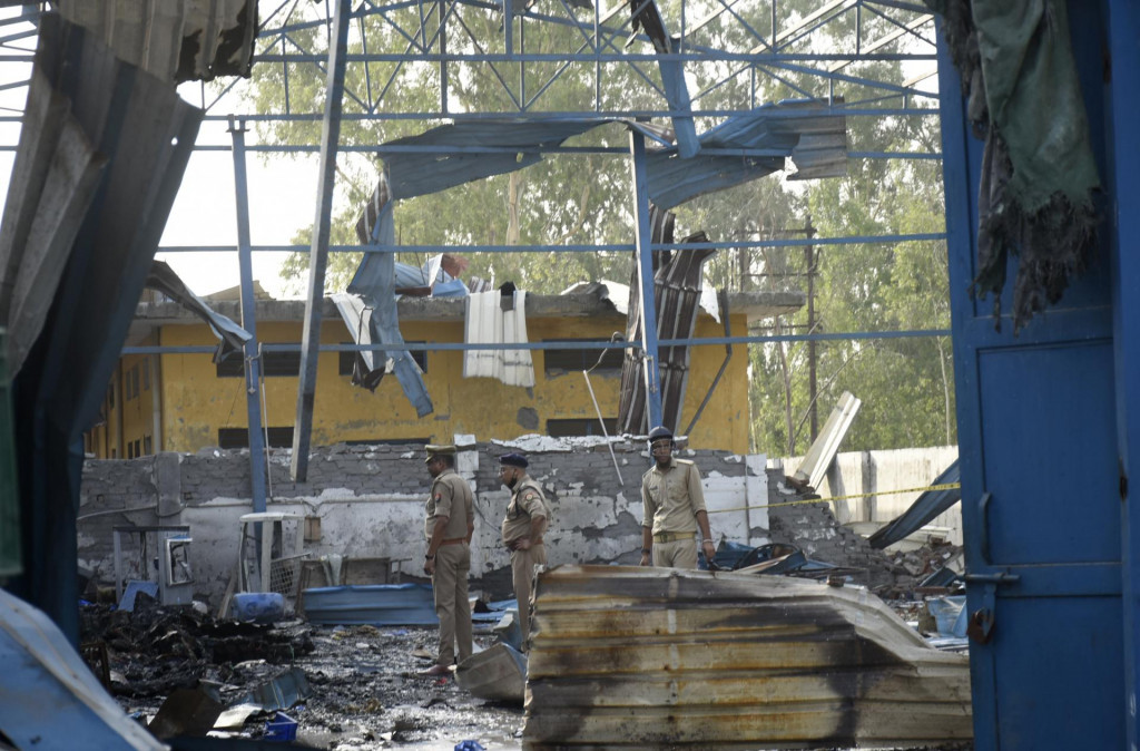 Policajti skúmajú miesto požiaru v indickom meste Hapur, kde zahynulo najmenej desať robotníkov. FOTO: TASR/AP