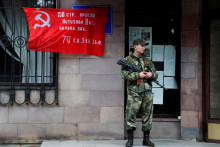 Príslušník proruských jednotiek na stráži pred budovou mestskej civilnej a vojenskej správy v Doneckej oblasti,. FOTO: REUTERS