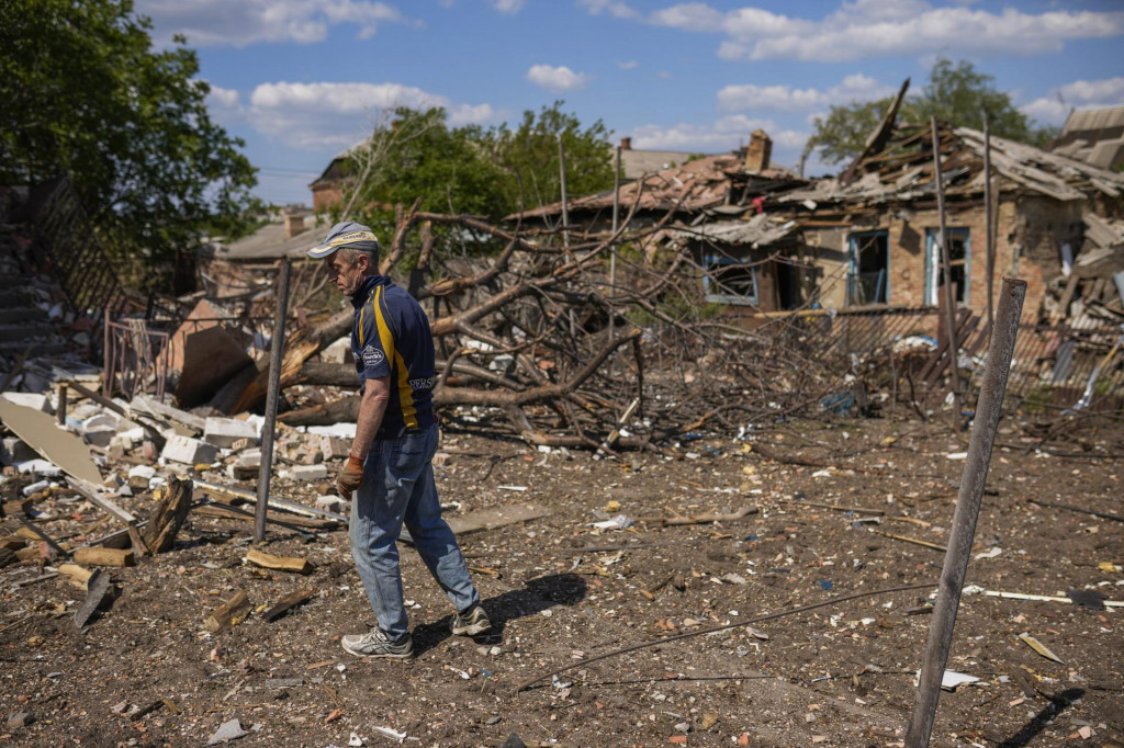 Muž vedľa trosiek domu zničeného po ruskom ostreľovaní v meste Bachmut na Ukrajine. FOTO: TASR/AP