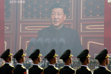 Vojaci čínskej armády stoja pred obrovskou obrazovkou, z ktorej sa k ním prihovára prezident Si Ťin-pching. FOTO: Reuters