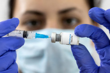 Zravotníčka drží maketu injekčnej liekovky s nápisom ”Vakcína proti opičím kiahňam” a lekársku striekačku. FOTO: Reuters