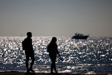 &lt;p&gt;Ľudia kráčajú na pobreží Baltského mora v nemeckom rezorte Warnemuende. FOTO: Reuters&lt;/p&gt;