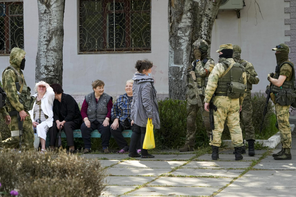 Ruskí vojaci v ukrajinskom meste Cherson, ktorí sa rozprávajú s miestnymi obyvateľmi. FOTO TASR/AP

