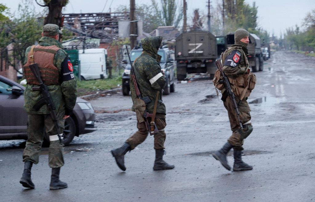 Príslušníci proruských jednotiek čakajú na odchod ukrajinských vojajkov z oceliarní Azovstaľ. FOTO: Reuters